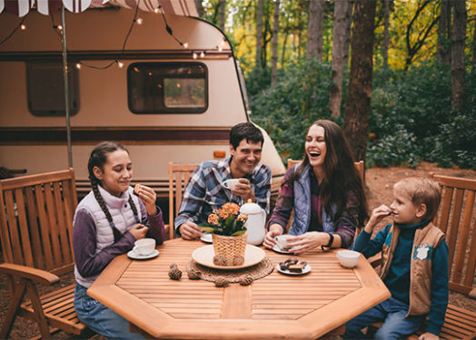 Happy family on a camping trip relaxing in the autumn forest.