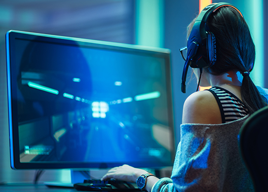 Female video game player seated and playing a video game